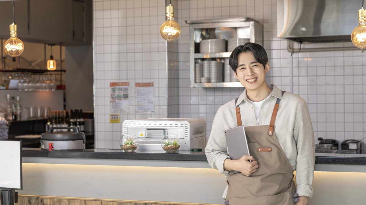 가게 주방에서 태블릿을 든 젊은 사장